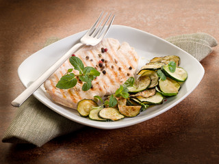 chest of grilled chicken with zucchinis and mint leaf
