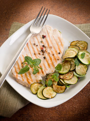 chest of grilled chicken with zucchinis and mint leaf