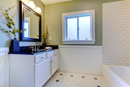 Classic green and white bathroom with ceramic tiles.
