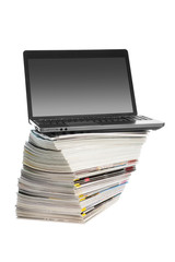 Online magazines -Laptop on a piles of magazines