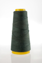 Spool of dark green thread isolated