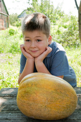 Fototapeta premium Boy with a big melon in his hand, harvest
