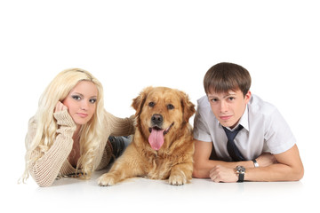 A young family with a dog on floor, looking at camera