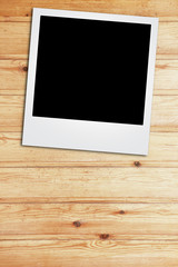 instant photo frame on wooden background.