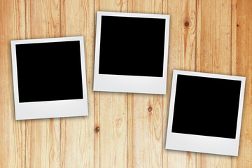 instant photo frame on wooden background.