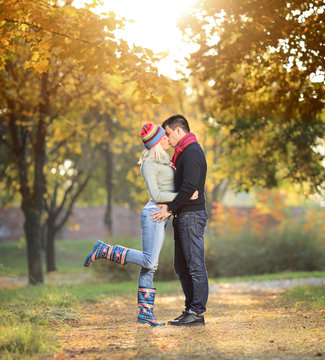 Loving couple kissing in the park in autumn