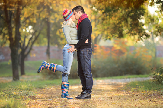 Loving couple kissing in the park in autumn