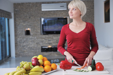 Obraz premium happy beautiful blonde woman prepare food in the kitchen