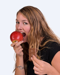 Young woman eating an red apple and chocolate