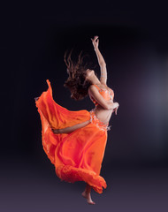 beauty dancer jump in orange veil - arabian style