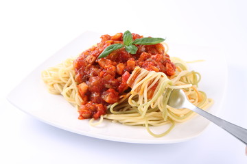 Spaghetti bolognese on a plate being eaten with a fork