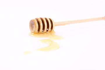 Honey on a honey stick and on a white background