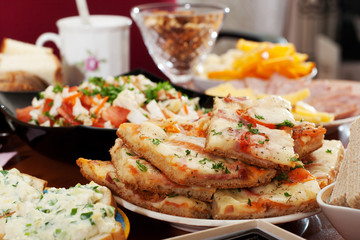 Photo holiday table with pizza, salads and other foods