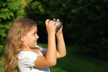 The little girl with the old camera in a white dress