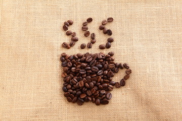 Fototapeta na wymiar coffee bean arranged to a cup of hot coffee