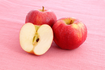 fresh Red Apple with water drop on pink background
