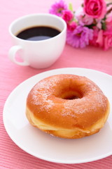 sweet sugar donut with a cup of coffee