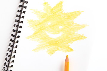 notebook (with sun) and yellow pencil on white background