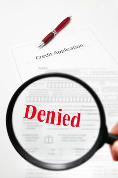 a blank credit application and magnifying glass with Denied text