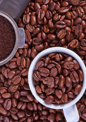 Overview shot of espresso grounds and cup with beans