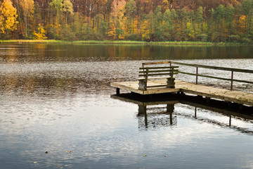 Old wooden jetty over the lake at autumn