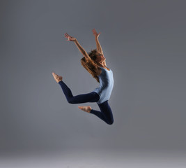 Fototapeta na wymiar A young Caucasian female dancer caught in a jump