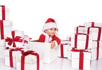 Baby boy in Santa Claus costume sitting inside gift box