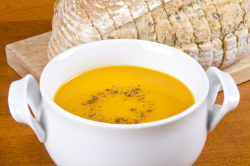 Bowl of Carrot Soup and Sliced Herb and Olive Bread