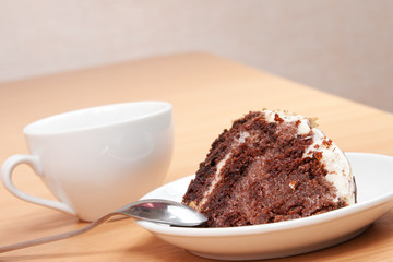 tasty chocolate cake on a plate with a cup