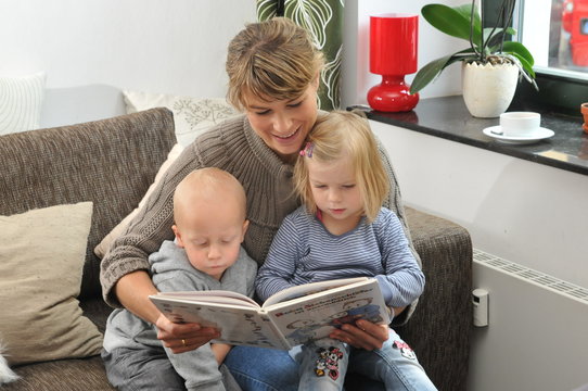 Mutter lie&szlig;t Kindern aus einem Buch vor 3