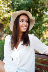 Portrait of a sexy young female smiling in a park while sitting