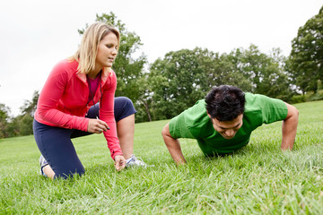 Trainer coaching man doing push ups