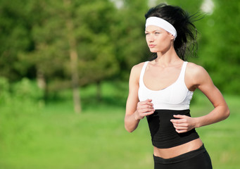 Fototapeta premium Woman running in green park