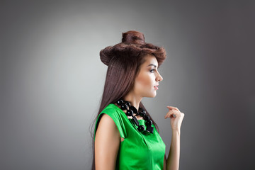 Cute woman posing in hair style hat - green dress