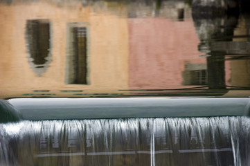 Reflections of colored walls and waterfall in Annecy