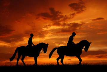 horse riders in the sunset