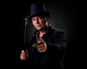 Handsome man wearing black hat and jacket pointing on you