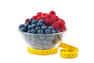 Raspberries and blueberries wrapped with measuring tape