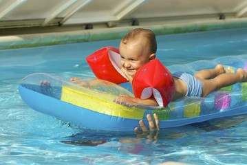 enfant sur un matelas à la piscine