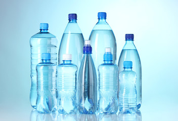 Group plastic bottles of water on blue background