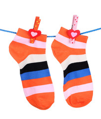 Obraz premium Bright striped socks on line isolated on white