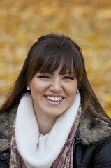 Portrait of beautiful young woman smiling outdoors in autumn