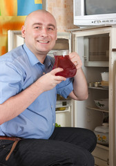 man putting jug with fruit-drink