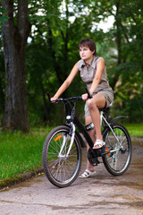 Naklejka premium Girl on bicycle in a park.