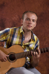 Obraz premium Young man playing classic spanish guitar