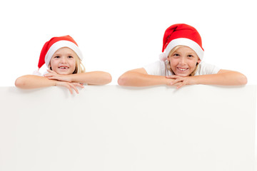 glückliche kinder mit weihnachtsmütze und werbeschild