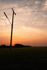 Fototapeta na wymiar Electrical pole on sunset background