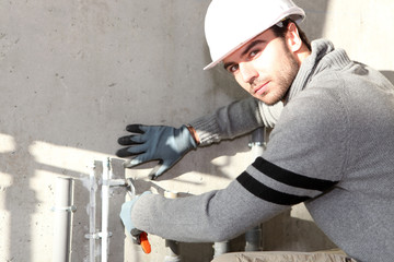 Builder cutting an outdoor pipe