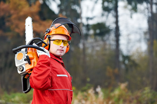 Lumberjack Worker With Chainsaw In The Forest