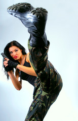 Fototapeta na wymiar Dziewczyna z pistoletem w kopnięcie ruchu